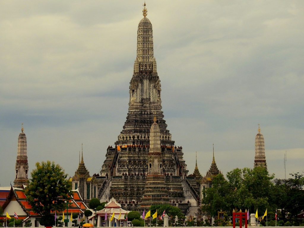 Wat arun temple complex against a cloudy sky