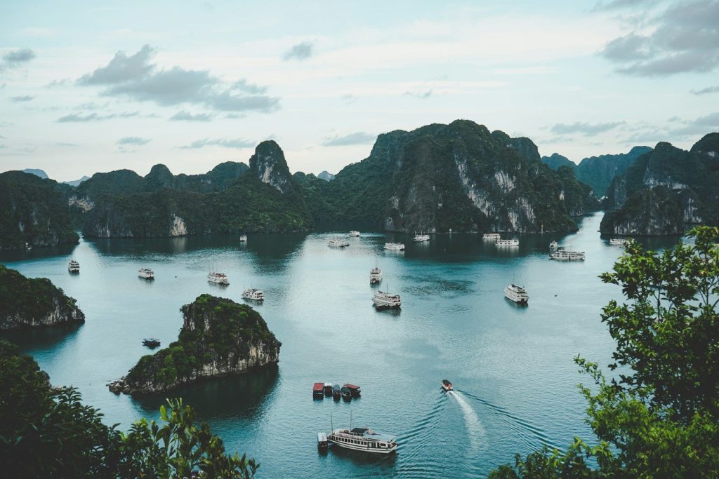 High-angle photography of boats on the water near a hill during the day
