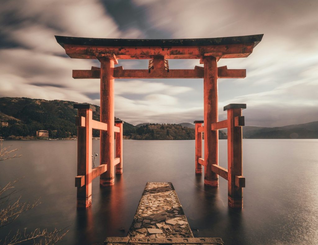 A red torii gate standing in the water at Lake Ashi in Hakone, Japan